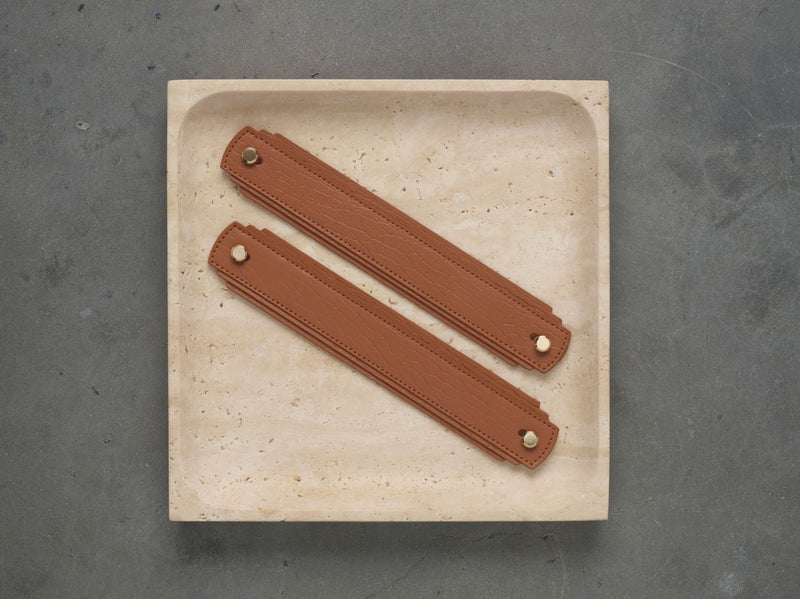 Tan leather handle by Sagitine, featuring a smooth finish and a sturdy design.