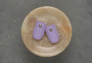 Lavender leather pull handle by Sagitine, featuring a sleek design perfect for cabinets or drawers.