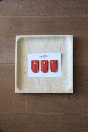 Raspberry leather pull handle by Sagitine, featuring a sleek design and vibrant pink color.